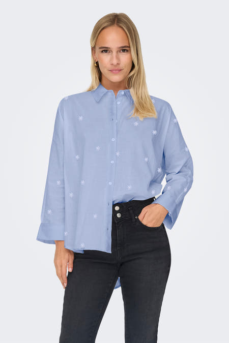 Blauw overhemd met lange mouwen van ONLY, met subtiel bloemmotief en gedragen met een zwarte jeans.
