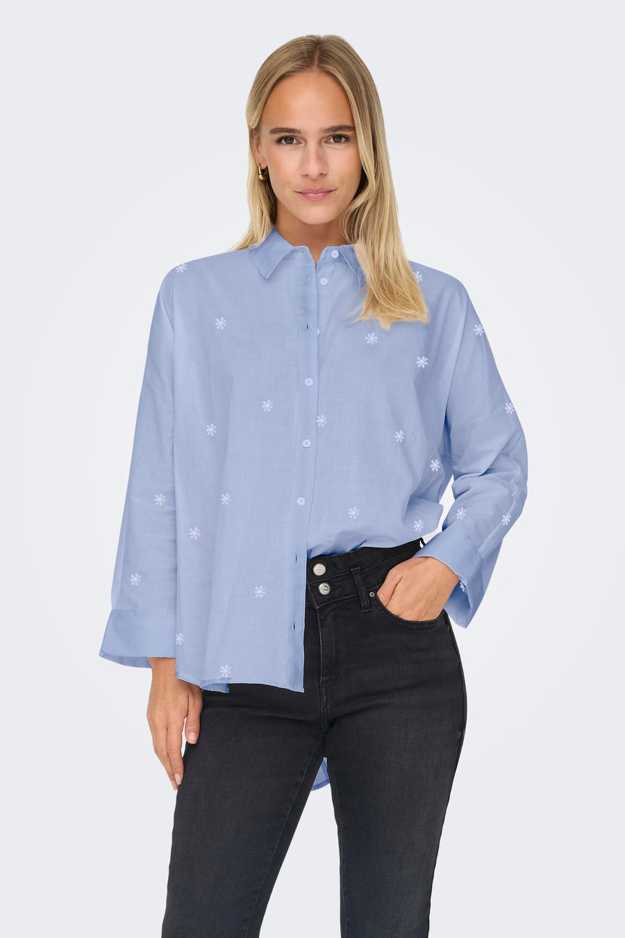 Blauw overhemd met lange mouwen van ONLY, met subtiel bloemmotief en gedragen met een zwarte jeans.

