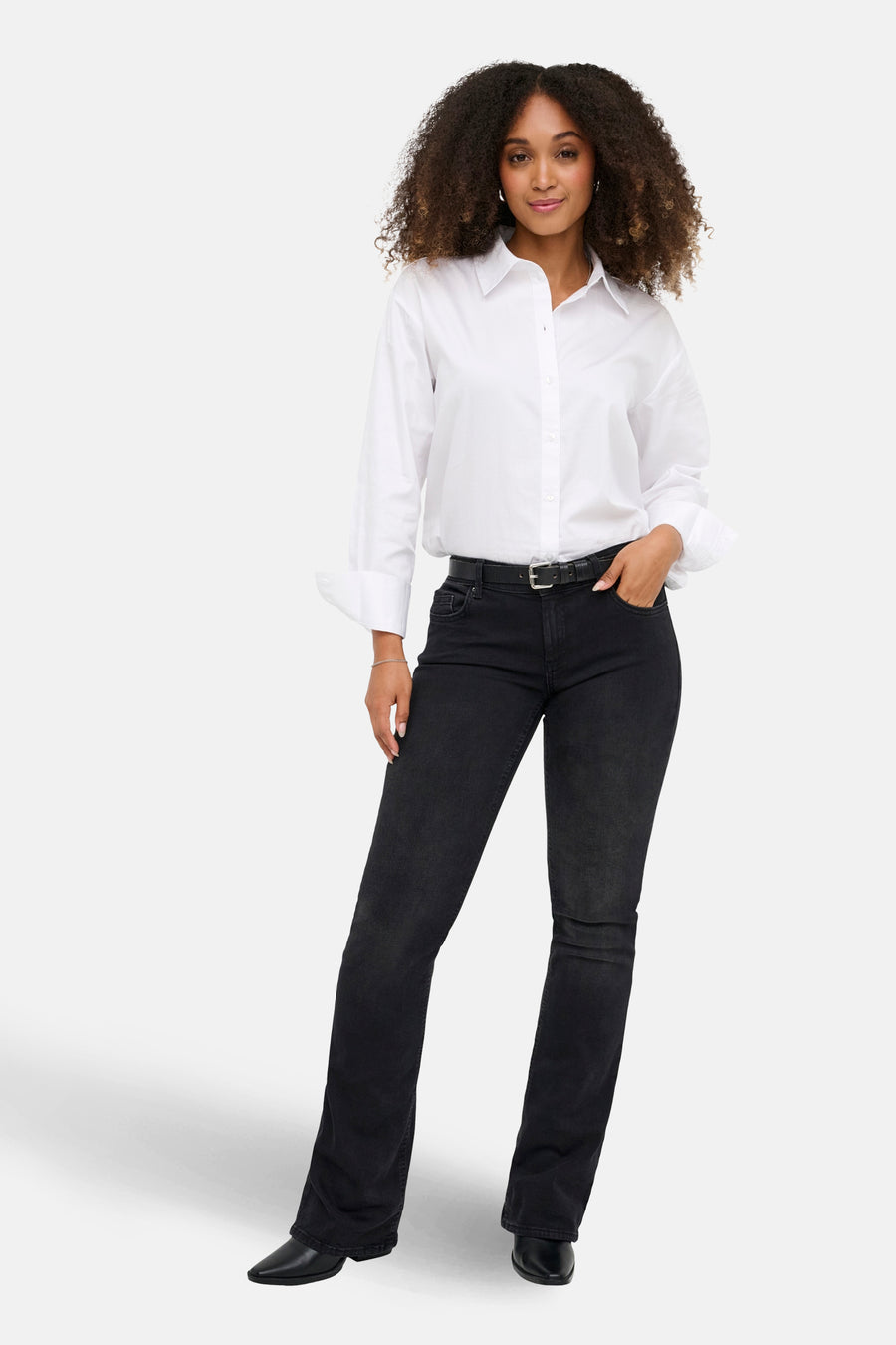 Zwarte flared jeans van ONLY, gedragen met een witte blouse en een zwarte riem.
