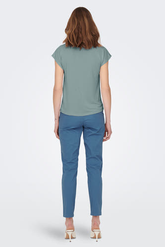 T-shirt vert avec manches courtes de ONLY®, porté avec un pantalon bleu et des baskets blanches, vue arrière.