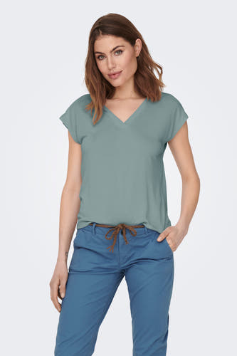 T-shirt vert avec manches courtes de ONLY, porté avec un pantalon bleu et une ceinture tressée.