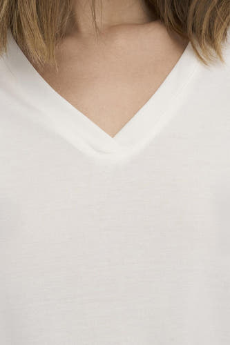 Wit T-shirt van ONLY met V-hals en zichtbare huid en haar.
