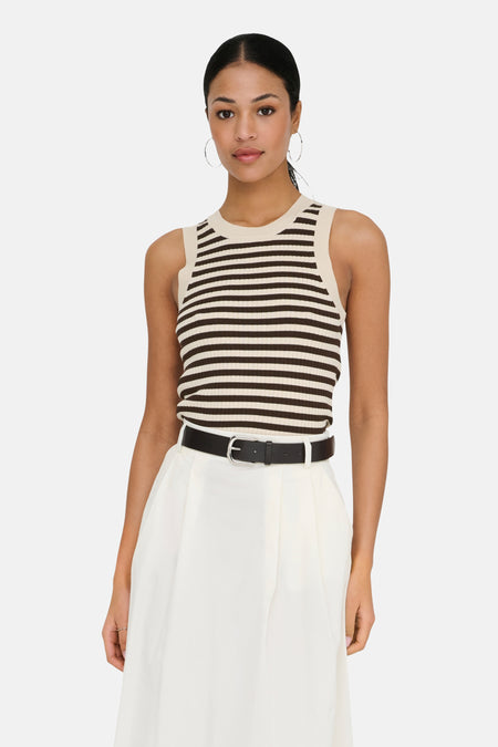 Haut rayé sans manches en beige et marron foncé de JDY, combiné avec une jupe midi blanche et des chaussures Mary Jane noires.