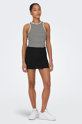 Zwarte skort van JDY met een overslagdetail, gecombineerd met een gestreepte top en witte sneakers.

