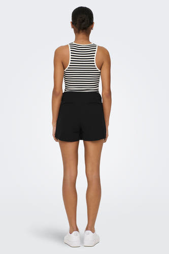 Zwarte skort van JDY, met het uiterlijk van een rokje en een verborgen broekje, gecombineerd met een gestreepte top en witte sneakers.
