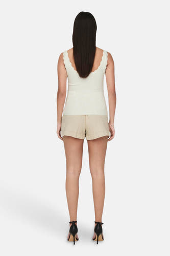 Witte geribde mouwloze top van JDY met geschulpte halslijn, gedragen door een vrouw in khaki shorts en zwarte hakken, van achteren gezien.