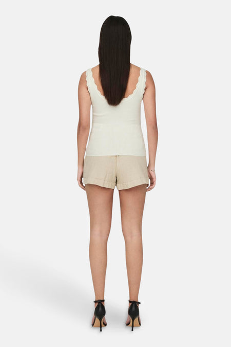 Witte geribde mouwloze top van JDY met geschulpte halslijn, gedragen door een vrouw in khaki shorts en zwarte hakken, van achteren gezien.