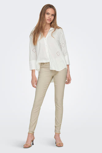 Wit hemd met lange mouwen van JDY, met broderie details en gecombineerd met een lichtbruine broek en hakken.
