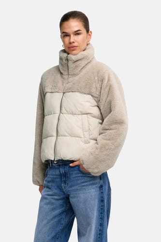 Lichtgrijze pufferjas met teddybontmouwen en kraag van ONLY®, voorzien van rits en zakken, gedragen met blauwe jeans.