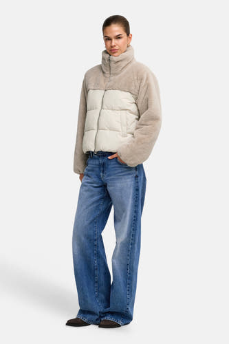 Lichtgrijze pufferjas met teddybontmouwen en kraag van ONLY®, crèmekleurig geplooid middenstuk, frontzip, model draagt blauwe wijde jeans