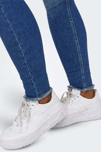 Jean skinny en denim bleu marine de ONLY, avec des poches froncées, associé à des baskets blanches.