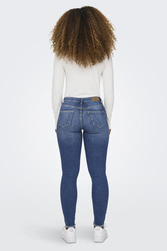 Jean skinny bleu ONLY, vu de derrière avec avec un t-shirt et des baskets blanches.