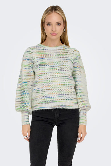 Beige trui van ONLY, met gemêleerd multicolor patroon en lange pofmouwen, gedragen met zwarte broek.
