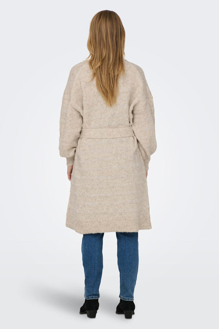 Beige gilet van ONLY, met ceintuur en gedragen over een jeans met zwarte laarsjes, gezien vanaf de achterkant.
