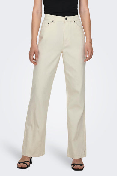 Ecru kleurbroek van ONLY, met een subtiel visgraatmotief en gecombineerd met zwarte sandalen en een gouden armband.