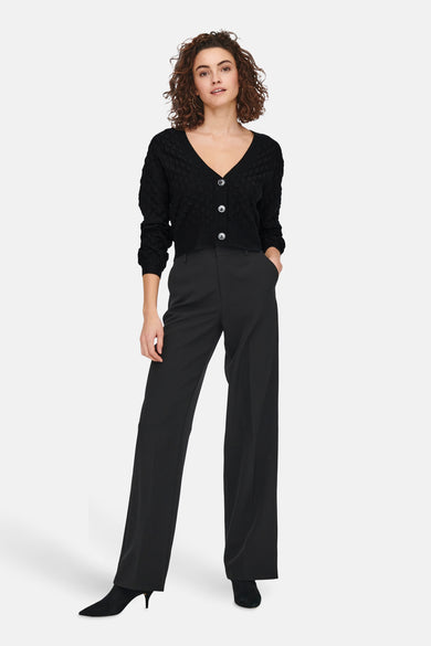 Gilet noir ONLY, avec un motif de bulles tricotées, un décolleté en V et une fermeture à boutons.