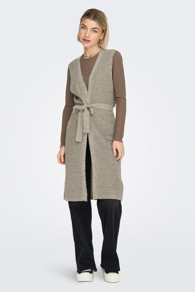 Bruin gilet van JDY met een gebreide textuur, een strikceintuur en gedragen over een bruine top en zwarte broek.
