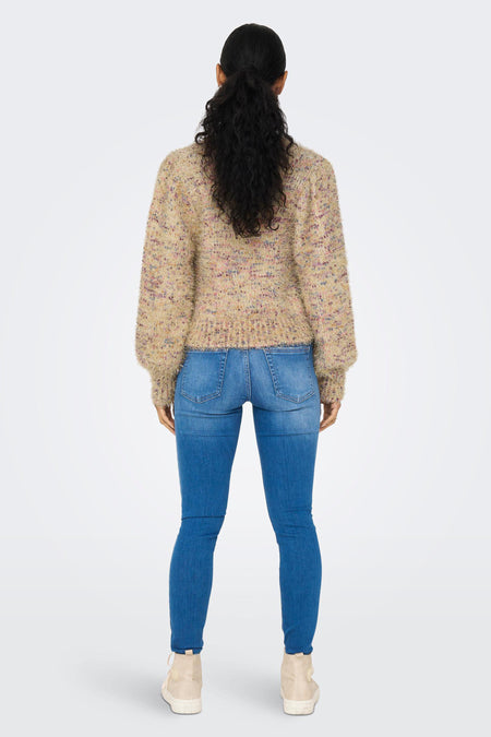 Veste en or ONLY, avec des manches longues et une texture bouclée, associée à des jeans bleus et des baskets.