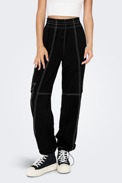 Zwarte cargobroek van ONLY, met opvallende witte stiksels en gecombineerd met zwarte hoge sneakers.