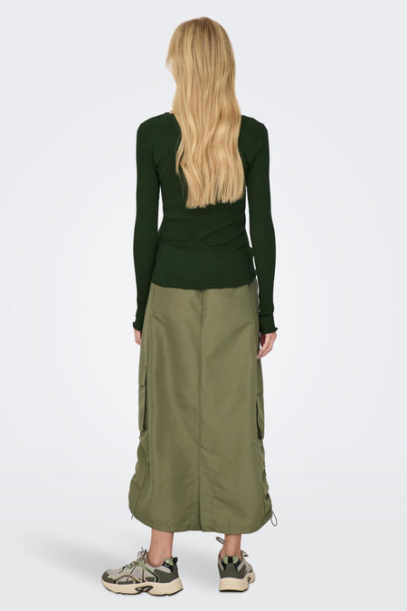Lange bruine rok van ONLY, met zakken en details met trekkoord, gecombineerd met een donkergroene top en sneakers.
