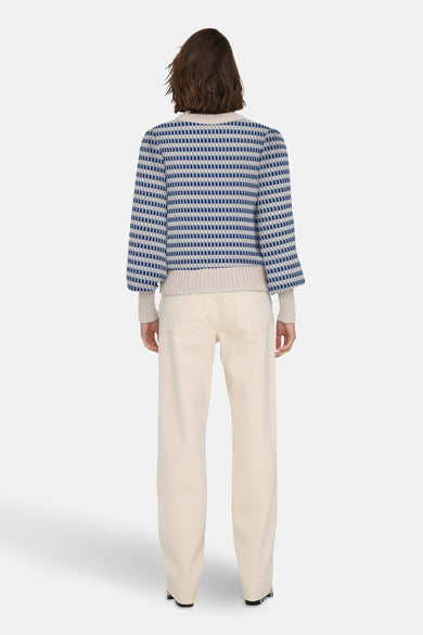 Blauwe trui met ronde hals van JDY, met een geometrisch patroon, gecombineerd met beige broek.
