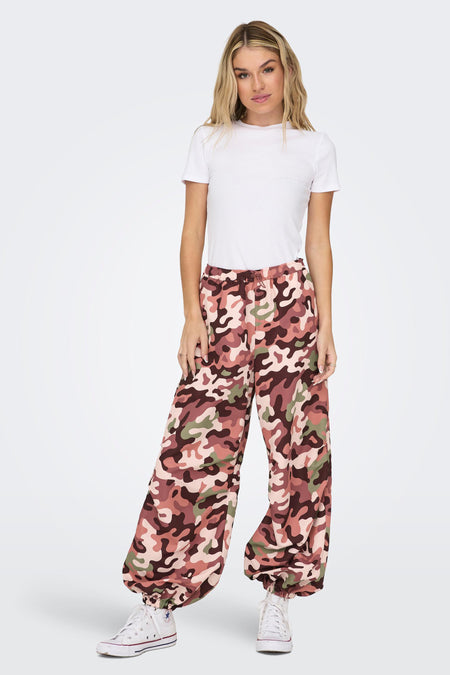 Camo broek van NEON & NYLON, met een elastische tailleband en wijde pijpen, gecombineerd met witte gympen en een wit t-shirt.
