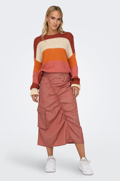 Roze driekwart rok van NEON & NYLON, met plooien aan de voorkant en zakken.
