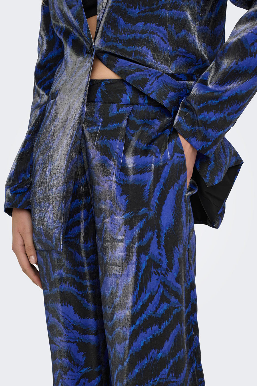Blauwe kostuumbroek van ONLY® met een opvallend tijgerprintpatroon en een glanzende textuur.
