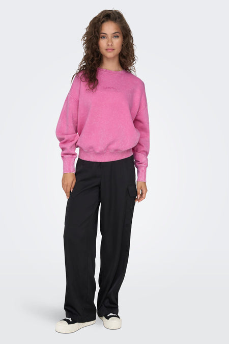 Roze sweater van ONLY®, met lange mouwen en een ronde hals, gedragen met een zwarte broek.