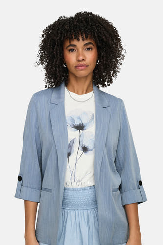 Blazer bleue de ONLY, avec manches trois-quarts, portée sur un t-shirt à imprimé floral et une chaîne argentée.