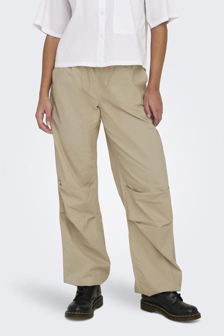 Beige broek van ONLY, met trekkoord en zakken, gecombineerd met een wit overhemd en zwarte schoenen.
