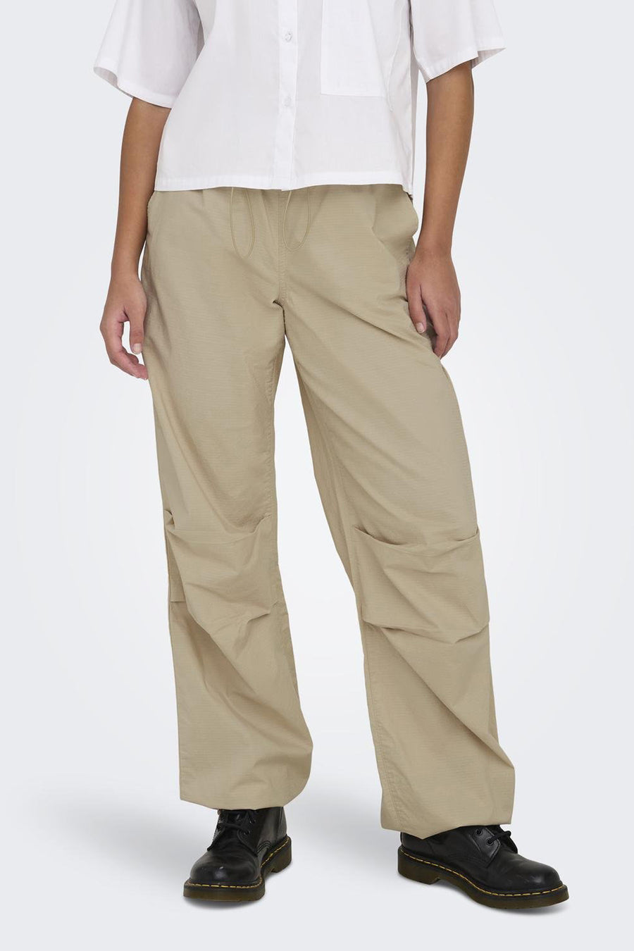 Beige broek van ONLY, met trekkoord en zakken, gecombineerd met een wit overhemd en zwarte schoenen.
