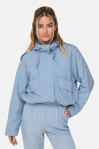 Vrouw in blauwe jack en pantalon.