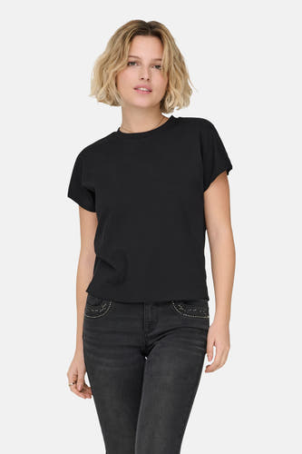 T-shirt noir à manches courtes de ONLY, porté avec un jean foncé orné de surpiqûres sur les poches.