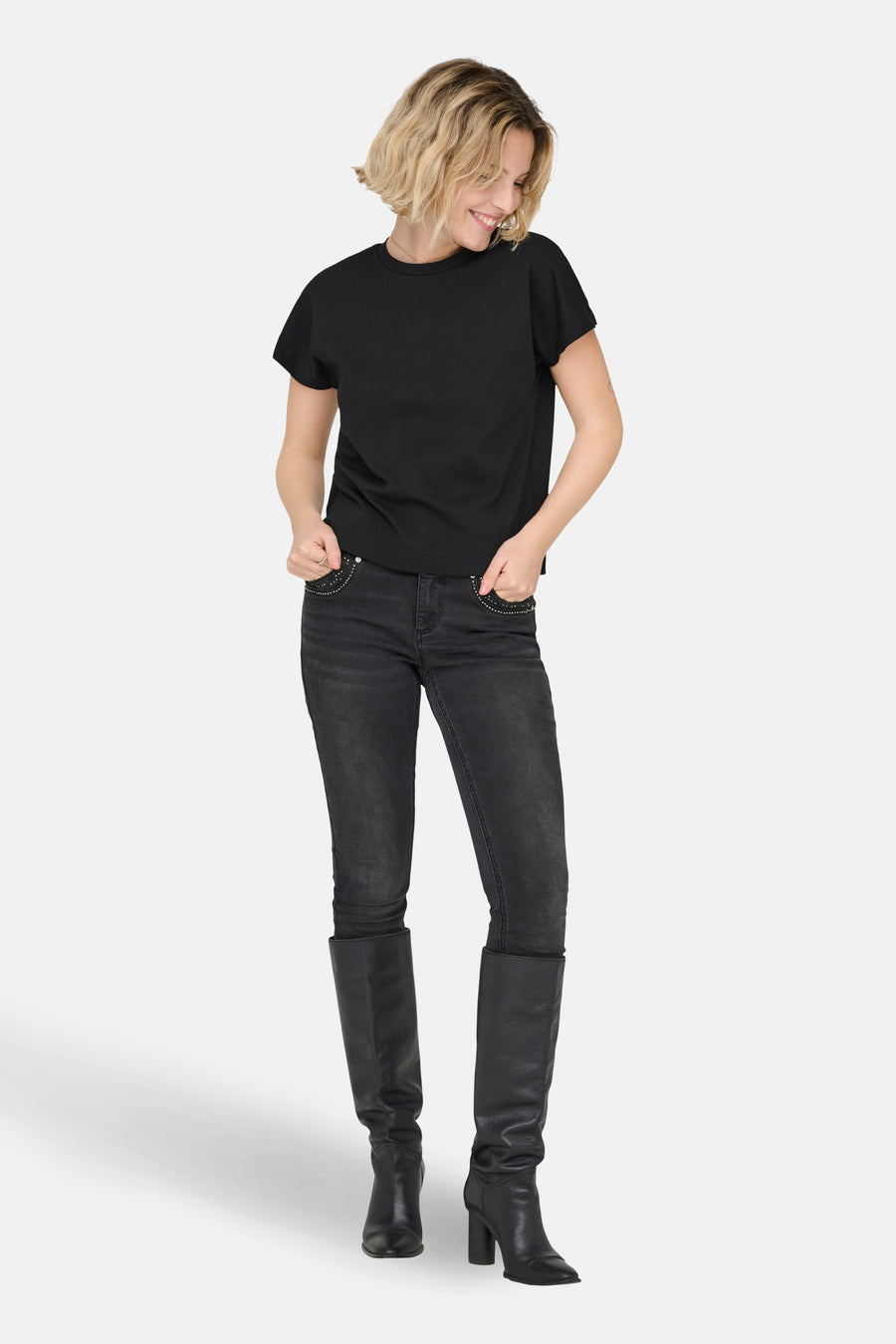 T-shirt noir à manches courtes de ONLY, porté avec un jean foncé et des bottes en cuir noires.