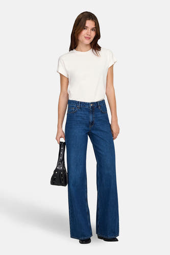 Wit T-shirt met korte mouwen van ONLY®, gedragen met wijde jeans en een zwarte handtas.
