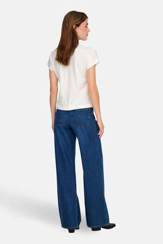 T-shirt blanc à manches courtes ONLY, vu de dos, combiné avec un jean bleu foncé à jambes larges.
