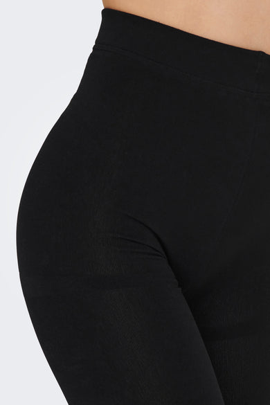 Zwarte legging van ONLY, close-up, met een strakke pasvorm en een subtiele ribstructuur.