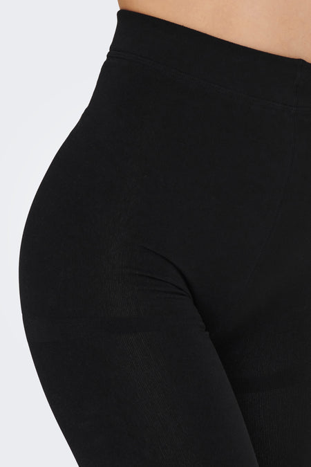 Zwarte legging van ONLY, close-up, met een strakke pasvorm en een subtiele ribstructuur.