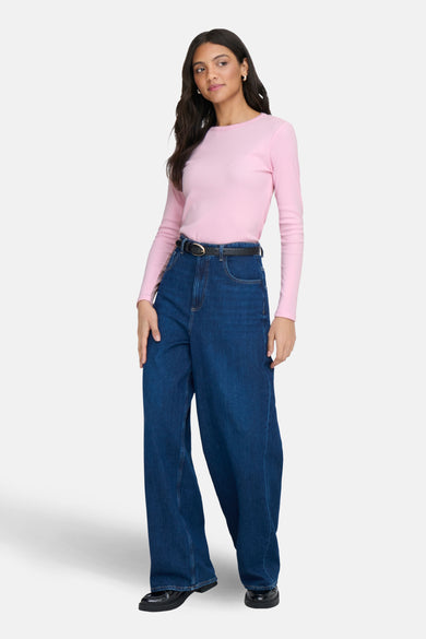Roze T-shirt met lange mouwen van JDY, gecombineerd met een blauwe jeans en zwarte riem.