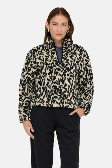 Zwarte fleece van ONLY, met een crème en zwart abstract patroon en een korte ritssluiting.
