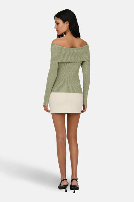 Pull vert émeraude à épaules dénudées de ONLY, à manches longues et à texture côtelée, combiné avec une jupe blanche.