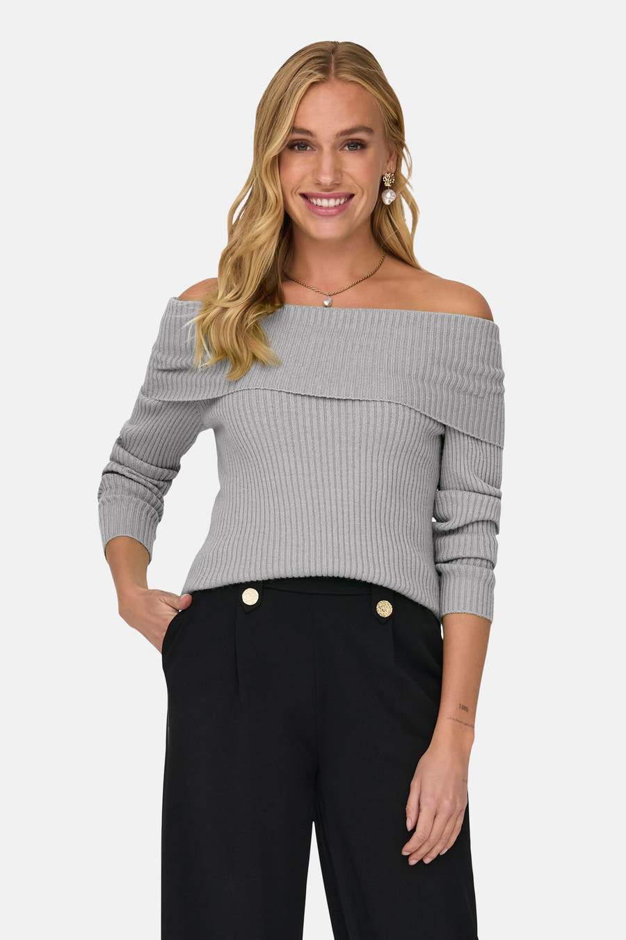 Grijze offshoulder trui van ONLY, met lange mouwen en gecombineerd met een zwarte pantalon met gouden knopen.