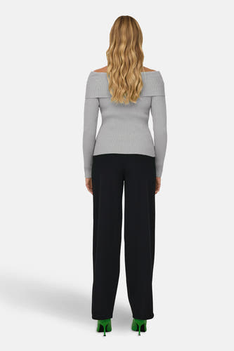 Grijze trui (offshoulder) van ONLY, met lange mouwen en gedragen met zwarte broek en groene hakken, achterkant.