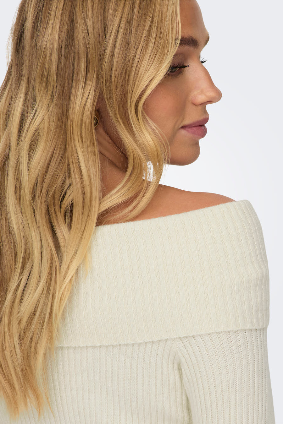 Witte offshoulder trui van ONLY®, met een ribgebreide textuur en een onbedekte schouder in zijaanzicht.
