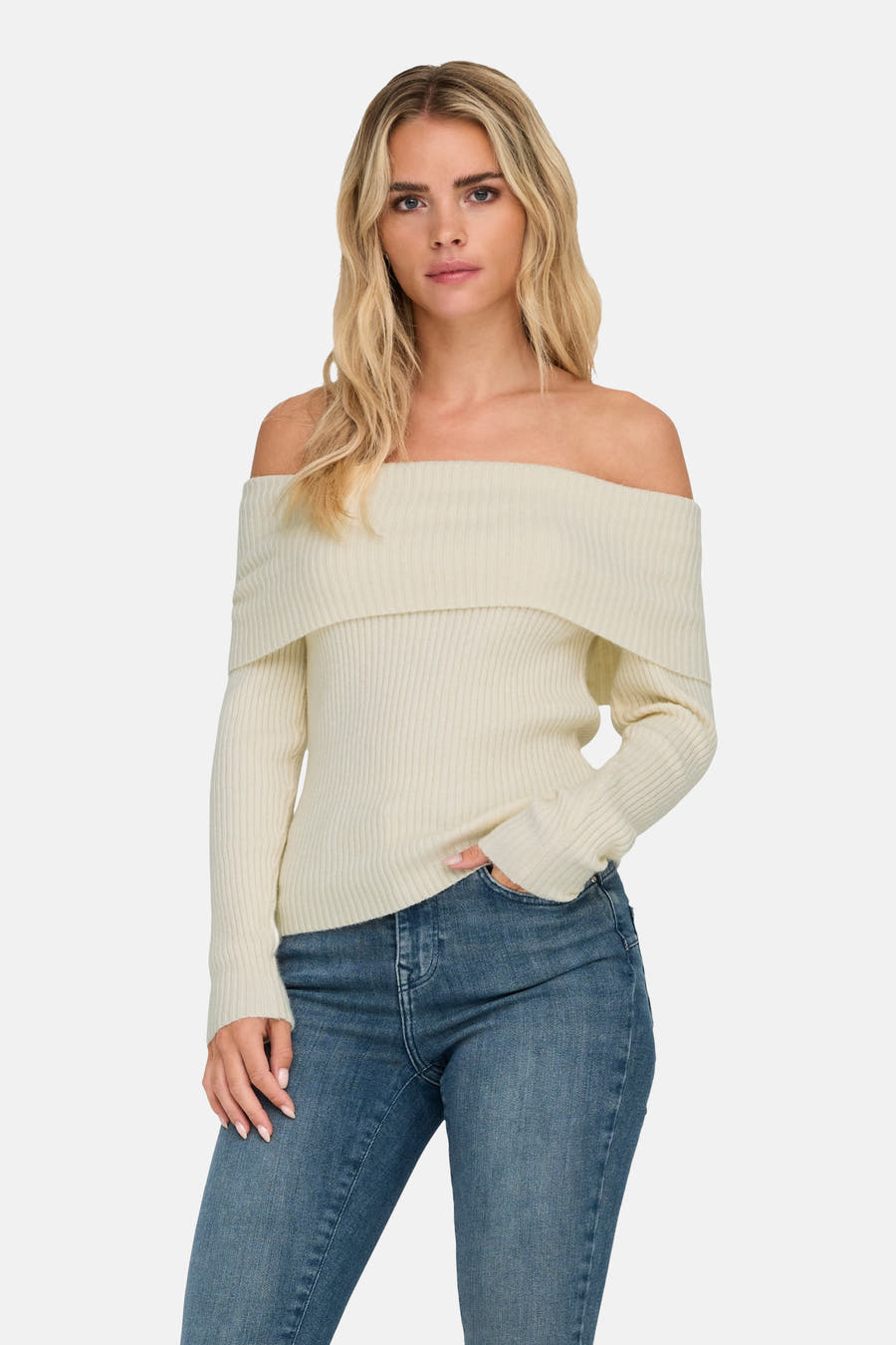 Witte offshoulder trui van ONLY, gedragen met blauwe jeans, en een hand in de zak.