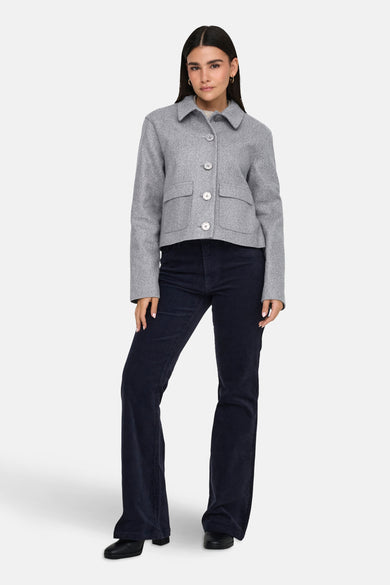 Grijs korte jas van JDY, met knopen, zakken en gecombineerd met donkerblauwe corduroy broek.