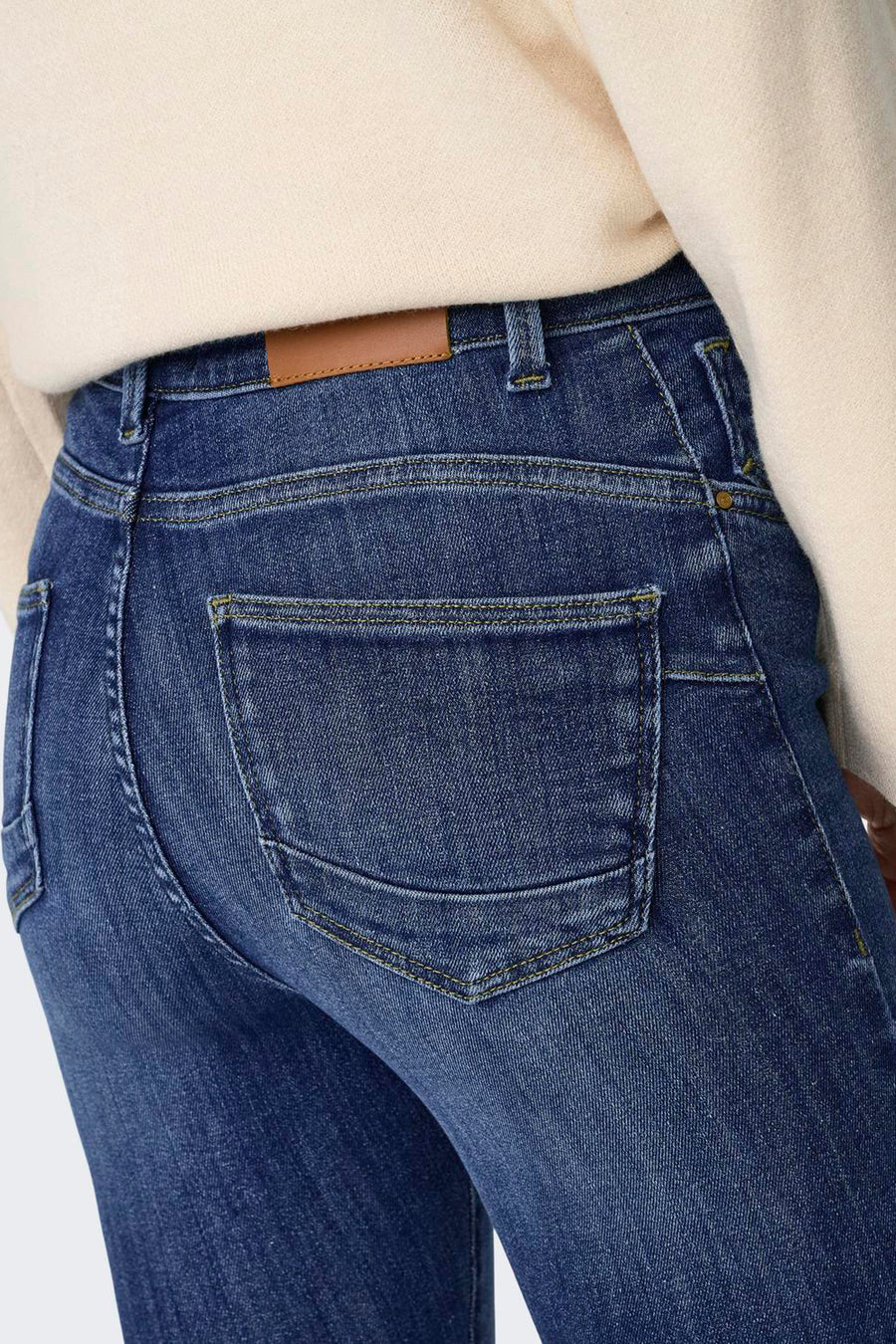 Achterkant van donkerblauwe skinny jeans van ONLY® met gele stiksels en klassieke achterzakken.