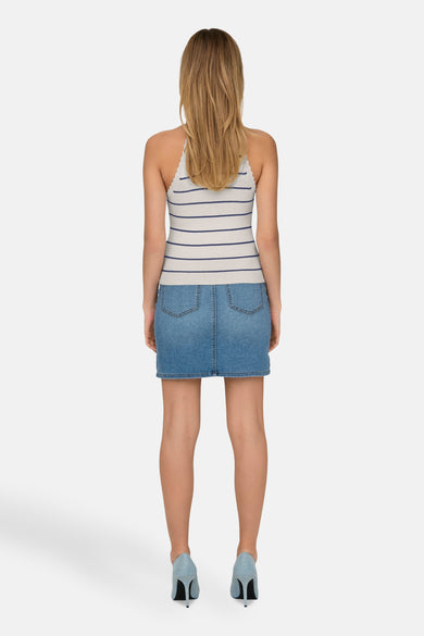 T-shirt sans manches blanc ONLY® avec des rayures bleues, associé à une jupe en denim et des baskets bleues.