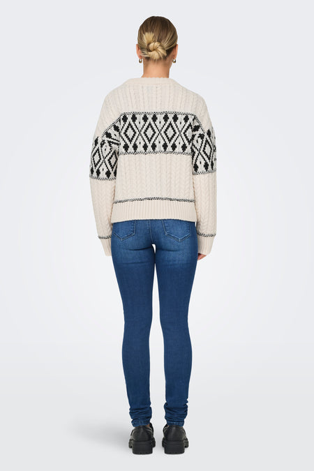 Ecru trui met ronde hals van ONLY®, met zwart geometrisch patroon op de schouders, gecombineerd met donkerblauwe jeans en zwarte schoenen.